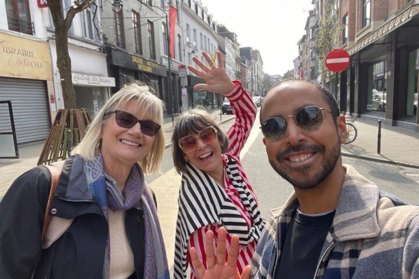 Three people on a city street with storefronts and a no entry sign. 1