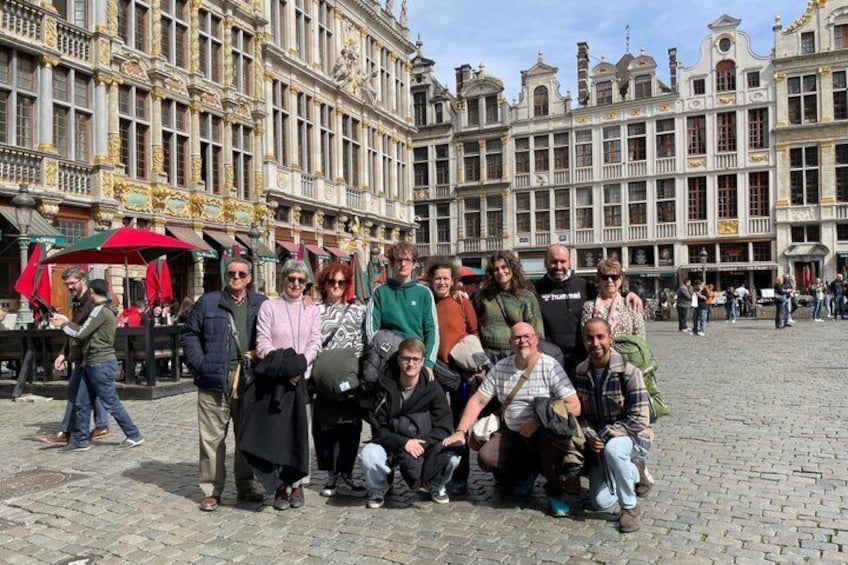 A group of people posing in a cobblestone square with historic buildings in the background. 5