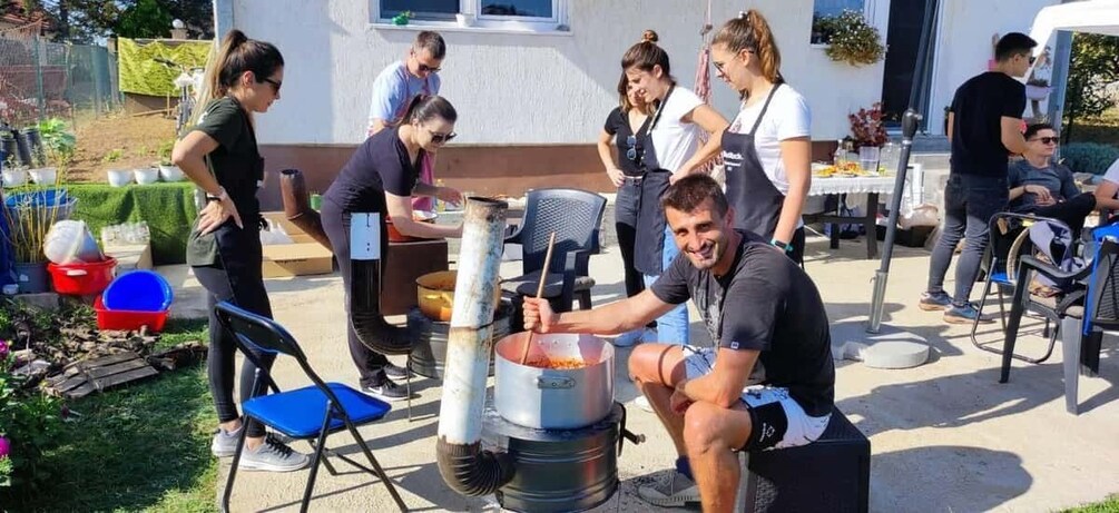 People cooking outdoors with a portable stove and pots. 4