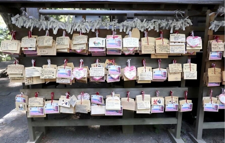 A wooden structure with multiple shelves displaying postcards and notes. 2