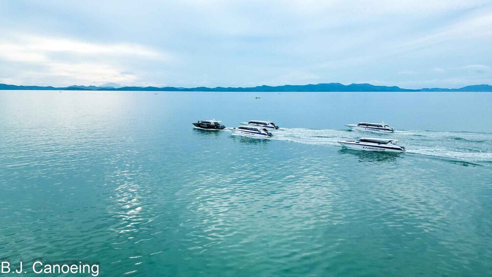 Four speedboats on a calm lake with mountains in the background. 5