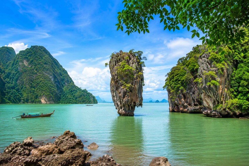 A boat on calm waters, surrounded by lush green cliffs and a clear blue sky. 1
