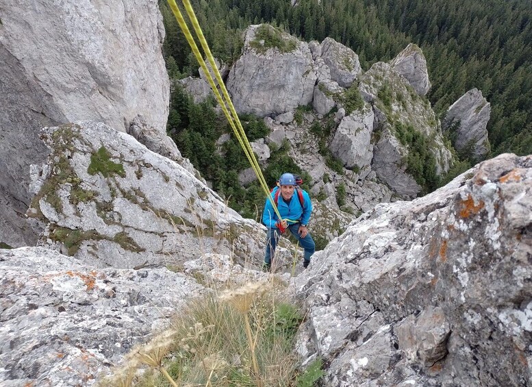 A person rappelling down a rocky mountain slope. 5