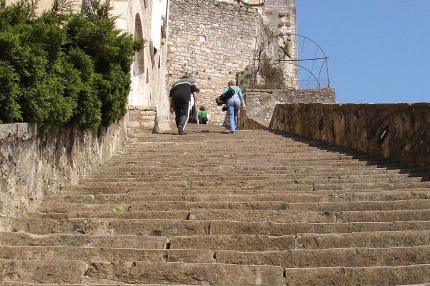 A stone staircase leading up to a historic building with a large wheel structure. 2