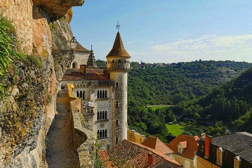 A medieval castle perched on a cliff overlooking a valley. 5