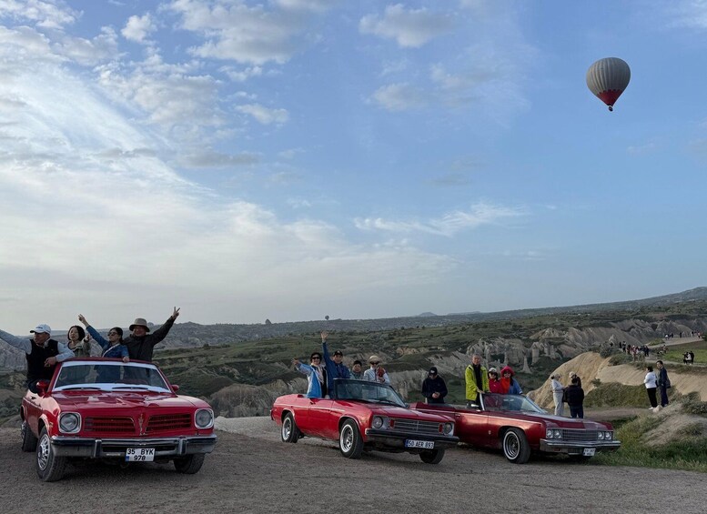 Vintage cars and a hot air balloon in a scenic outdoor setting. 5