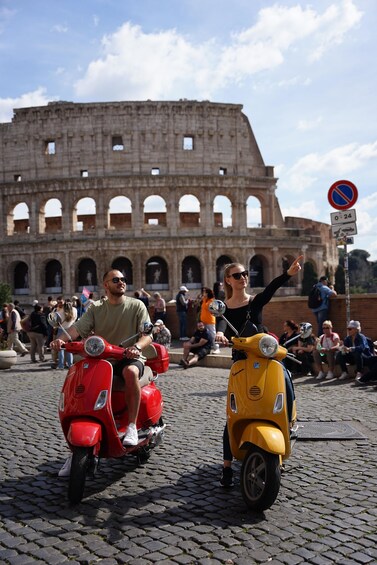 Two people riding scooters in front of the Colosseum. 4