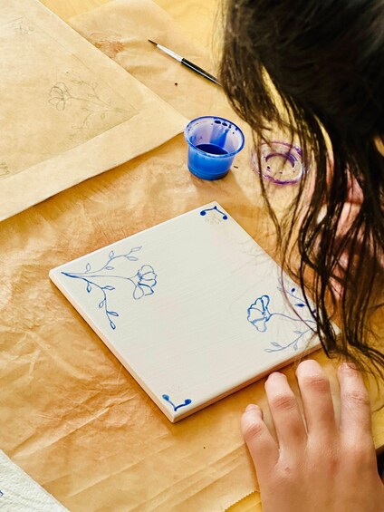 A hand holding a notebook with floral designs on a wooden surface. 2