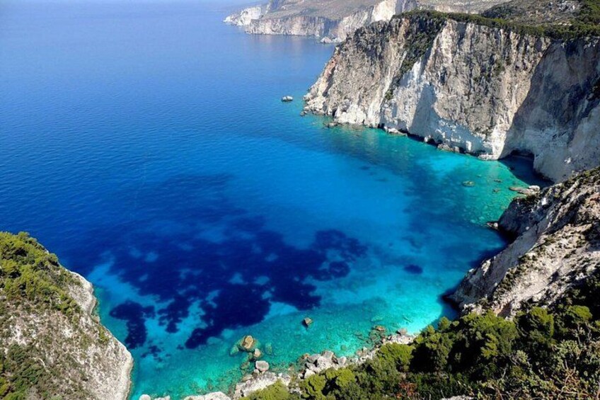 A coastal landscape with cliffs and clear blue waters. 1