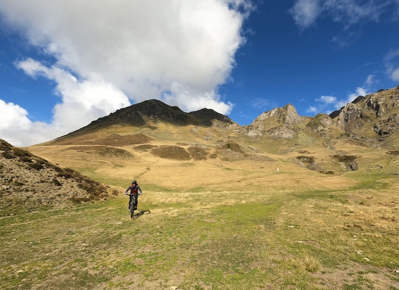 A hiker on a mountain trail with rocky terrain and a clear sky. 2