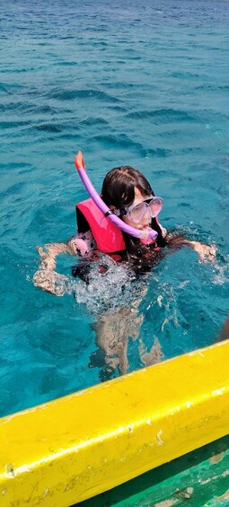 A person snorkeling in clear blue water with a snorkel and mask. 5