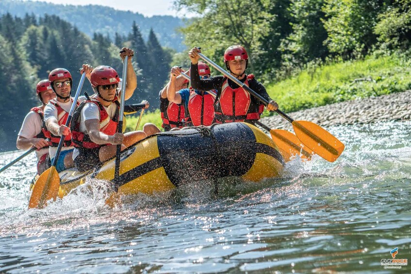 A group of people in a yellow and black raft on a river, wearing life jackets and helmets. 5