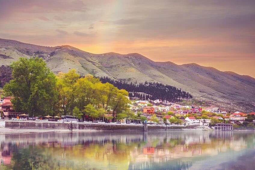 A lake with a town, trees, and mountains in the background. 4
