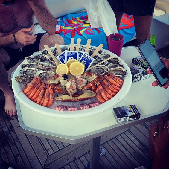 A seafood platter with oysters, shrimp, and lemon slices on a table. 5