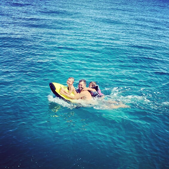 A family on a yellow raft in clear blue water. 3