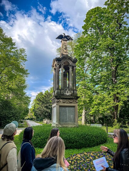 A monument with an eagle statue, surrounded by lush greenery and trees. 3