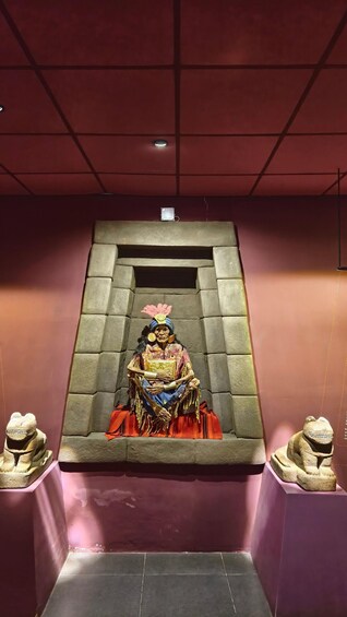 A statue of a seated figure in traditional attire, flanked by two stone animal figures, set within a stone structure. 4