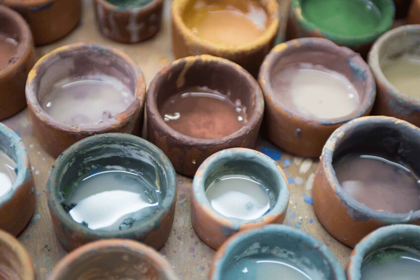 A collection of small, unglazed clay pots with varying colors and sizes. 1
