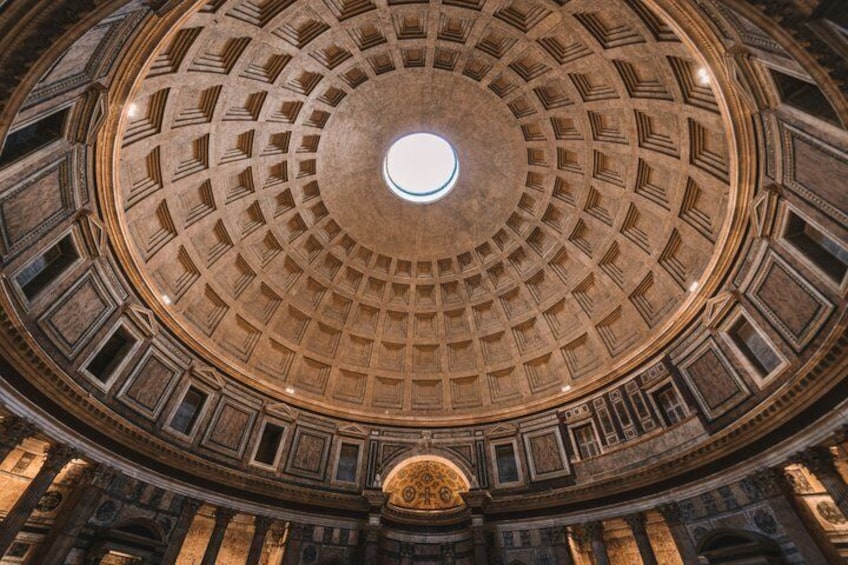 A grand, circular ceiling with a central skylight, ornate columns, and detailed stonework. 5