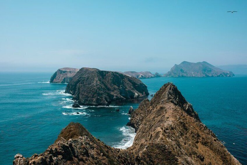 A coastal landscape with rugged cliffs and a clear blue sea. 5