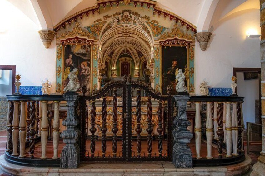 An ornate church interior with a central altar, statues, and a detailed ceiling fresco. 5