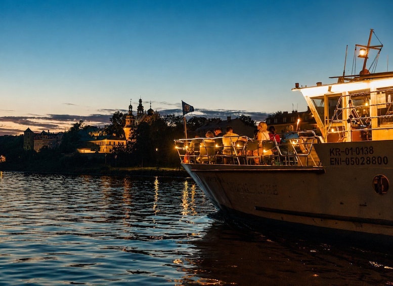 A boat docked at a pier with people on board, a castle in the background, and a clear sky. 3