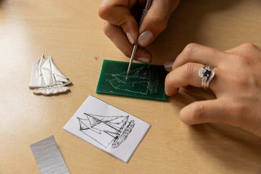 A person drawing a sailboat on a green board. 5