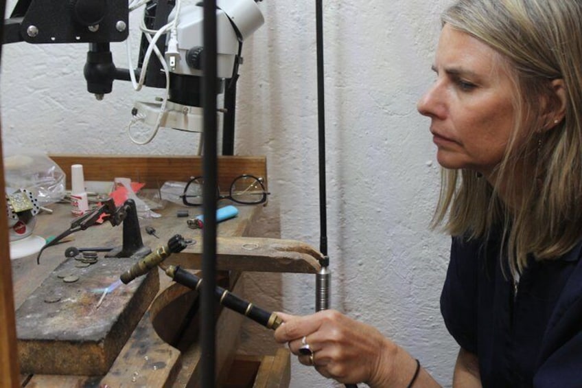 A person working with a tool on a workbench. 2