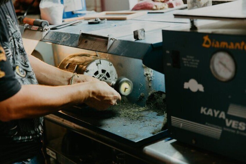 A person operating a machine with a dial and a label that reads 'KAYAVEST.' 3