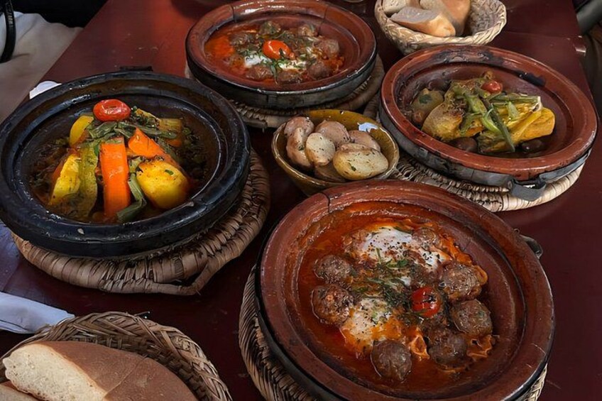 A variety of dishes served in traditional clay pots on a table. 4
