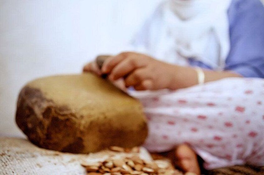A person sitting on a bench with a large rock and scattered nuts. 3