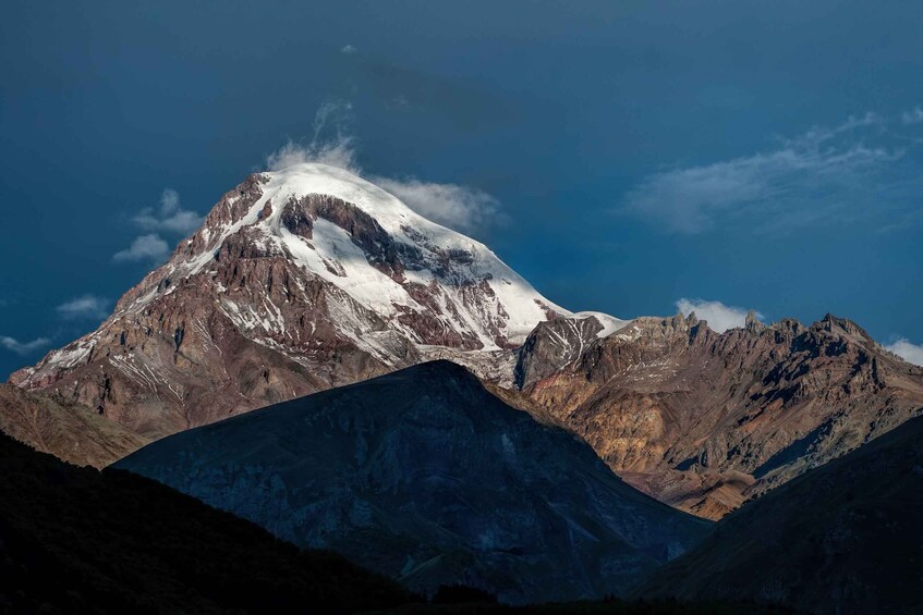 A snow-capped mountain with rugged terrain and a clear sky. 2