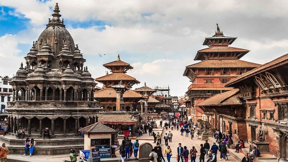 A bustling square with ancient temples and a prominent stupa. 5