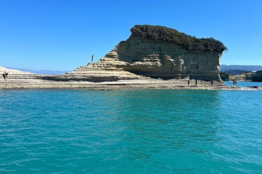 A coastal cliff with clear turquoise water. 1