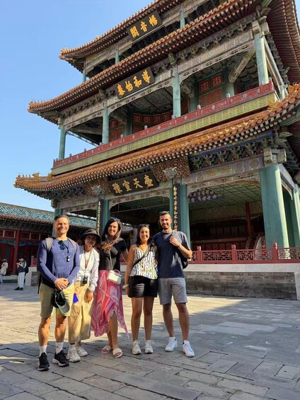A traditional Chinese building with ornate architecture and characters on the roof. 3