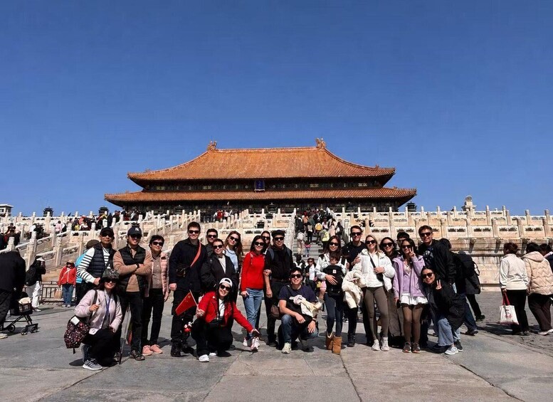 A group of people posing in front of a traditional Chinese building with a tiled roof. 2