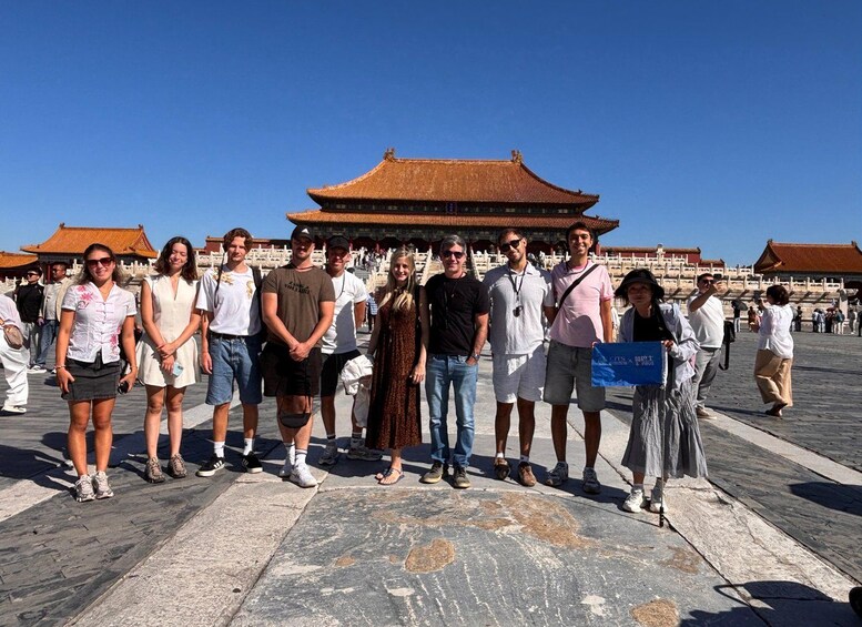 A group of people standing in front of a traditional Chinese building with a tiled roof. 4