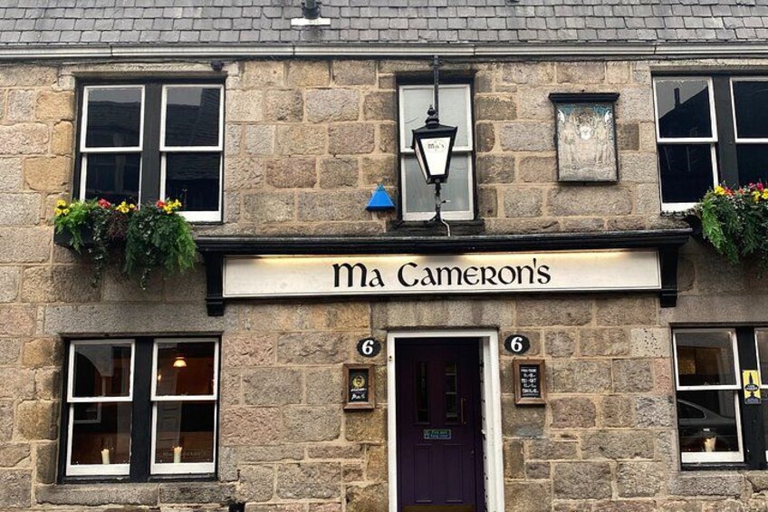A stone building with a sign reading 'Ma Cameron's' above the entrance. 4