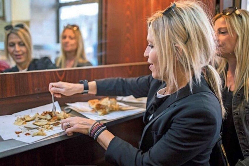 A person eating at a counter with a paper plate. 5