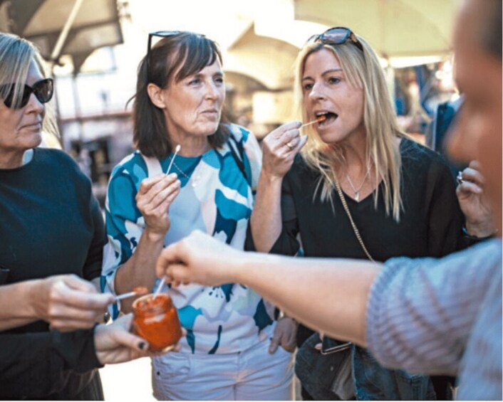 People eating at an outdoor event with food stands. 5