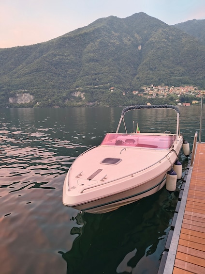 A boat docked at a wooden pier with a mountainous backdrop. 3