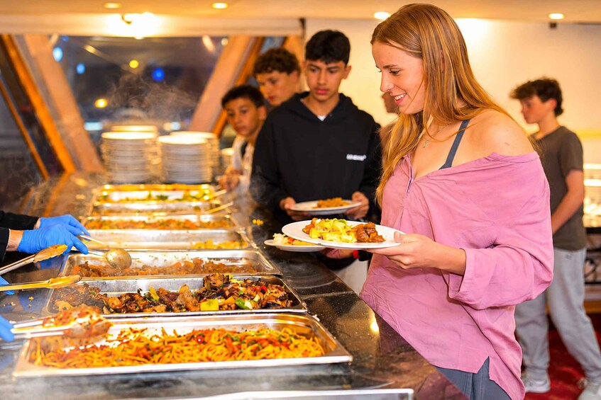 Un buffet proposant une variété de plats, notamment des pâtes et des viandes grillées. 3