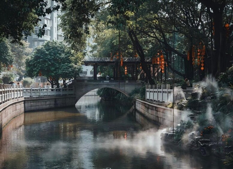 A stone bridge over a calm river, surrounded by trees and traditional lanterns. 5