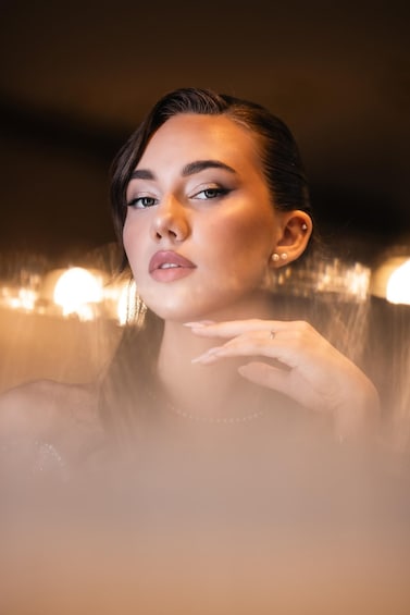 A person with a blurred background featuring lights. 1