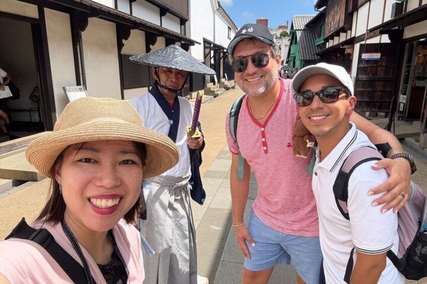 A street with traditional architecture, a person in a straw hat, and another in a striped shirt. 5
