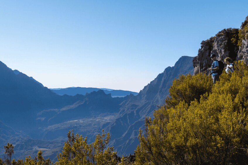 A mountainous landscape with hikers on a trail. 1