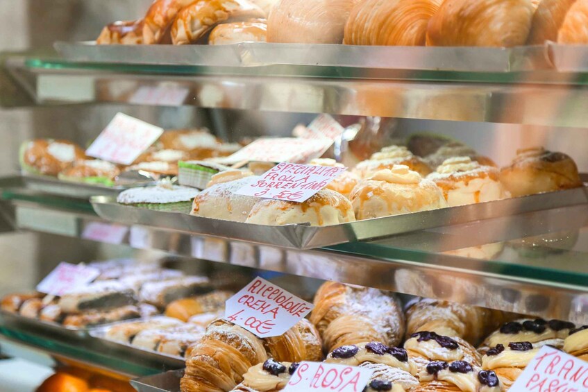 A bakery display with various pastries and desserts, including croissants and a special treat. 2
