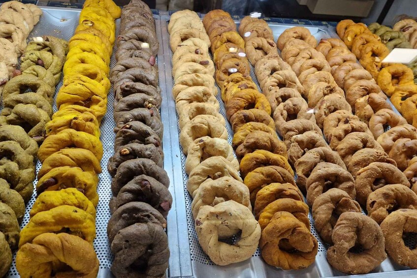 A display of various doughnuts arranged in rows. 3