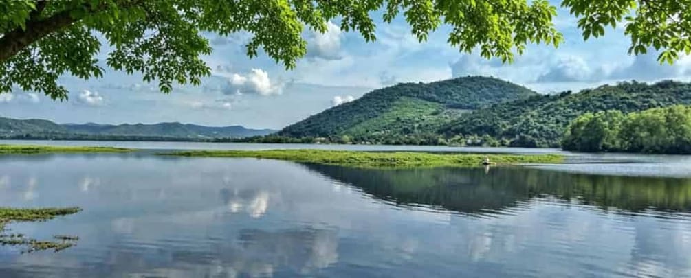 A calm lake with a forested hill in the background. 4