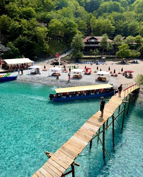 A wooden pier extending into clear turquoise water, with a boat docked at the end. 5